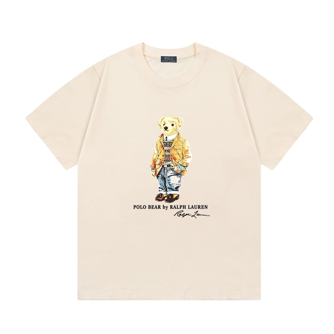 A cream-colored short-sleeve t-shirt featuring a central graphic of the iconic Polo Bear wearing a yellow jacket and blue jeans, with 'POLO BEAR by KALPI LAUREN' printed below.
