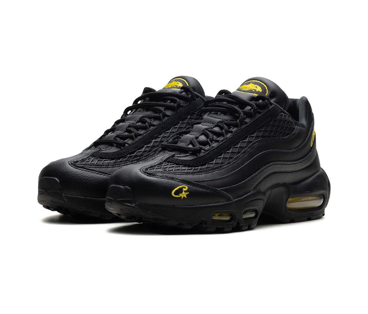 Black sneakers with yellow accents on a white background