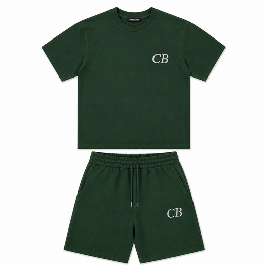 A dark green two-piece kids' outfit set consisting of a short-sleeve crewneck t-shirt and matching sweat shorts, both featuring a white embroidered 'CB' logo on the chest and left leg.
