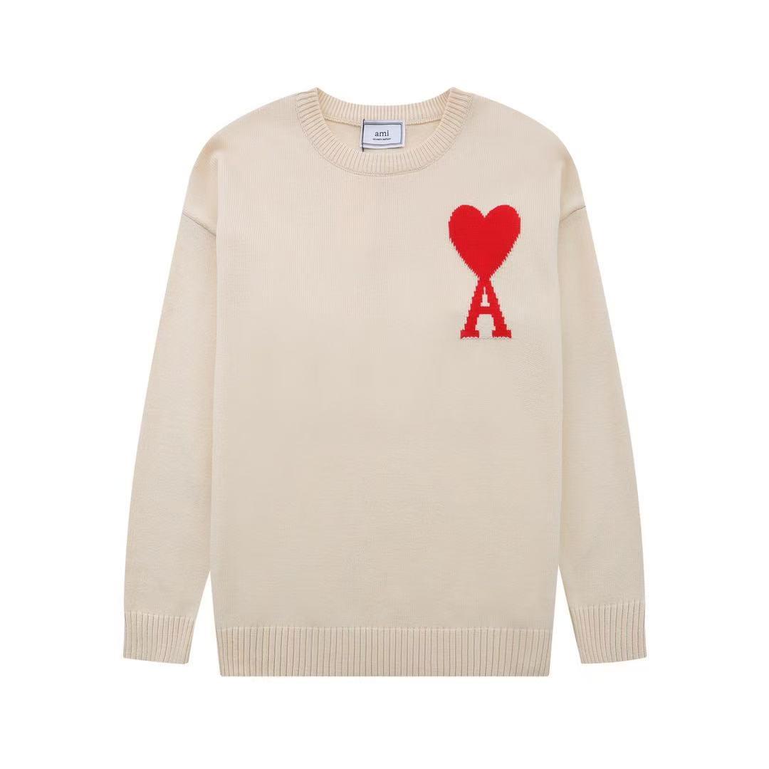 Beige sweater with a red heart and letter 'A' on a white background