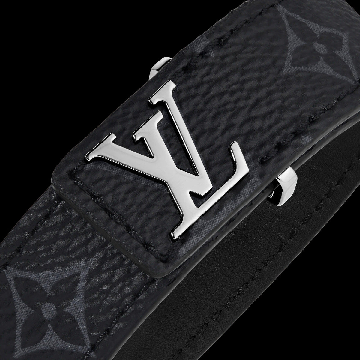 Black leather belt with silver monogram logo on a black background