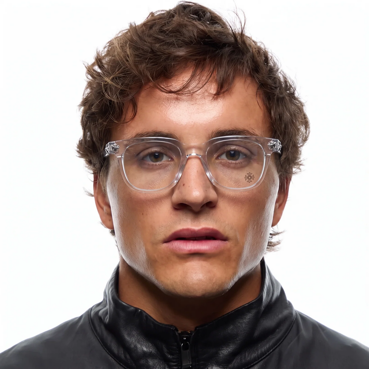 A close-up portrait of a man with brown hair wearing clear-framed eyeglasses and a black zip-up jacket against a plain white background.